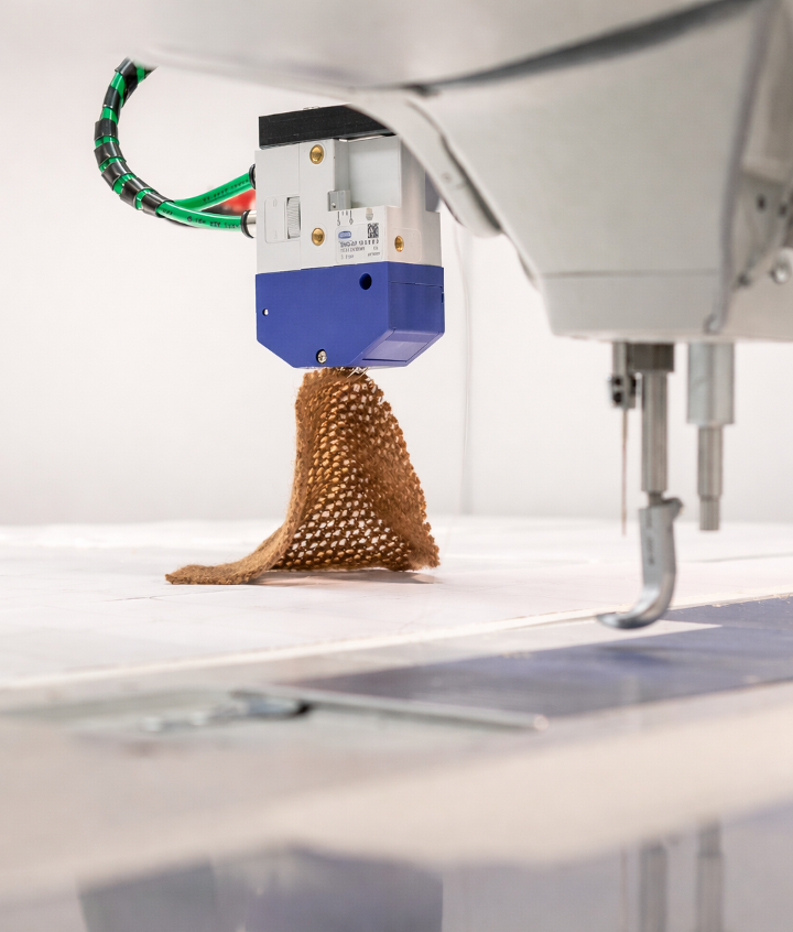 Close-up of ADOTC robotic textile handling with gripper and sewing environment